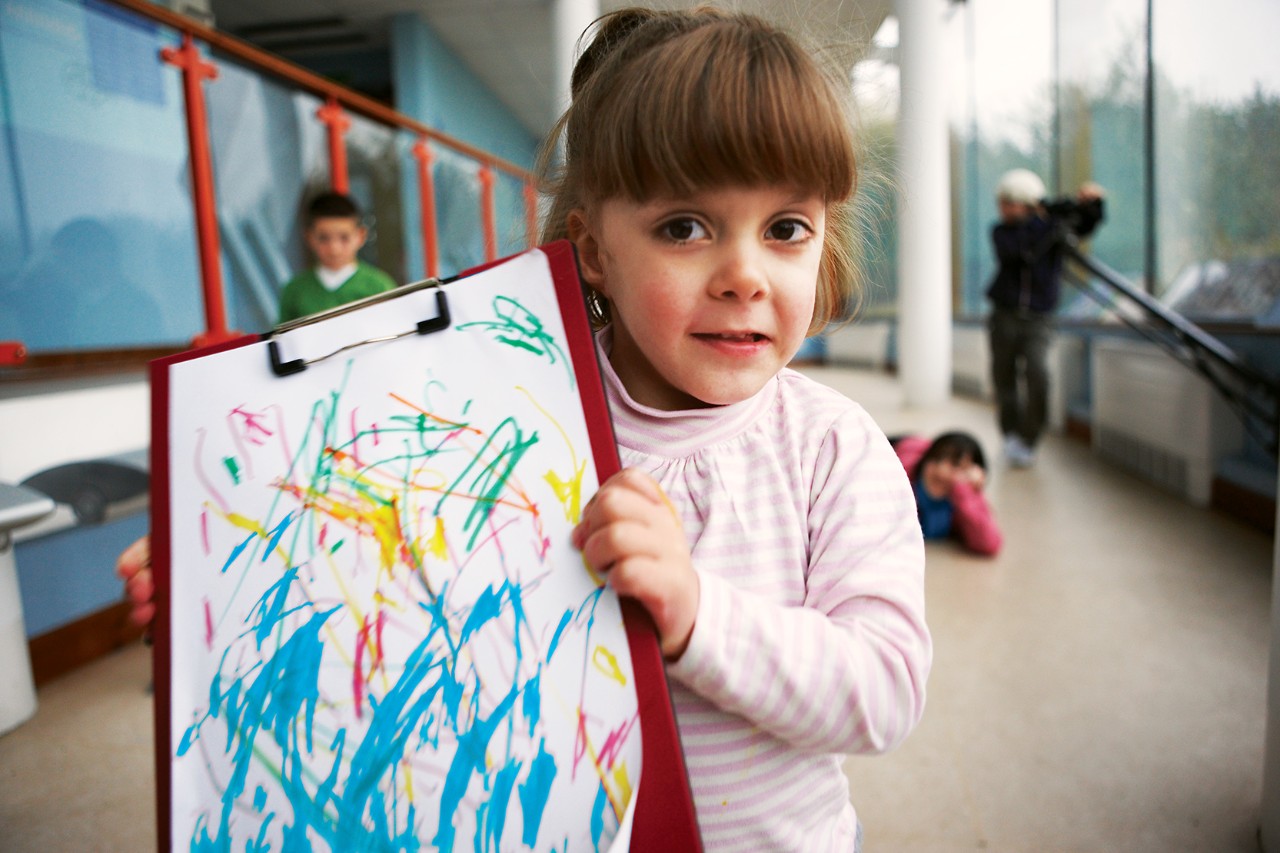 Girl holding a painting she made